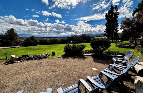 Medford Cottage | Wake to breathtaking sunrises over the rolling hills! Relax by the fire under the stars, & sunset dinners beneath fragrant wisteria pergola. Surrounded by wineries and minutes from historic Jacksonville. Charm, convenience & budget friendly.